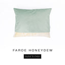 A bespoke luxury Dog Snuggle Bed made with a pale green woven upholstery fabric and cream faux-fur lining seen from above.
