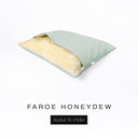 A cave bed style luxury Dog Snuggle Bed made with a pale green woven upholstery fabric and cream faux-fur lining.