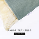 Corner detail of a luxury Dog Snuggle Bed, a sleeping bag style dog bed or cave bed style dog bed, with green-blue colored upholstery quality outer cover and plush cream faux-fur lining with Charley Chau's designer brand label.