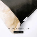 Close up of the corner of a luxury Dog Snuggle Bed, a cave bed style dog bed or sleeping bag style dog bed, with a black upholstery-quality velour / velvet outer cover and plush cream faux-fur lining, showing a Charley Chau designer brand label on the dog bed, on a white background.