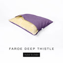 A Charley Chau Snuggle Bed, a cave bed or sleeping bag style dog bed made with a purple woven upholstery-quality fabric with cream, plush, faux-fur lining on a white backdrop.