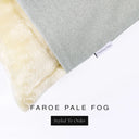 Corner detail of a luxury Dog Snuggle Bed, a sleeping bag style dog bed or cave bed style dog bed, with very pale grey colored upholstery quality outer cover and plush cream faux-fur lining with Charley Chau's designer brand label.