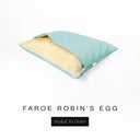 A Charley Chau Snuggle Bed, a cave bed or sleeping bag style dog bed made with a duck egg blue woven upholstery-quality fabric with cream, plush, faux-fur lining on a white backdrop.