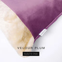 Close up of the corner of a luxury Dog Snuggle Bed, a cave bed style dog bed or sleeping bag style dog bed, with a deep plum purple upholstery-quality velour / velvet outer cover and plush cream faux-fur lining, showing a Charley Chau designer brand label on the dog bed, on a white background.