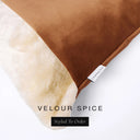 Close up of the corner of a luxury Dog Snuggle Bed, a cave bed style dog bed or sleeping bag style dog bed, with a burnt orange upholstery-quality velour / velvet outer cover and plush cream faux-fur lining, showing a Charley Chau designer brand label on the dog bed, on a white background.