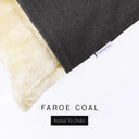 Corner detail of a luxury Dog Snuggle Bed, a sleeping bag style dog bed or cave bed style dog bed, with black colored upholstery quality outer cover and plush cream faux-fur lining with Charley Chau's designer brand label.