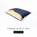 A Charley Chau Snuggle Bed, a cave bed or sleeping bag style dog bed made with a dark navy blue woven upholstery-quality fabric with cream, plush, faux-fur lining on a white backdrop.
