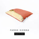 A Charley Chau Snuggle Bed, a cave bed or sleeping bag style dog bed made with an orange woven upholstery-quality fabric with cream, plush, faux-fur lining on a white backdrop.