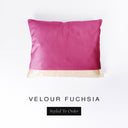 A bespoke, cave bed style Dog Snuggle Bed with fuchsia pink velvet outer cover and plush cream faux-fur lining on a white backdrop seen from overhead.