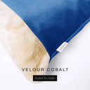 Close up of the corner of a luxury Dog Snuggle Bed, a cave bed style dog bed or sleeping bag style dog bed, with a bright cobalt blue upholstery-quality velour / velvet outer cover and plush cream faux-fur lining, showing a Charley Chau designer brand label on the dog bed, on a white background.