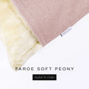 Corner detail of a luxury Dog Snuggle Bed, a sleeping bag style dog bed or cave bed style dog bed, with pink colored upholstery quality outer cover and plush cream faux-fur lining with Charley Chau's designer brand label.
