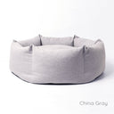 Luxury high-sided donut dog bed in pale blue on a white backdrop.