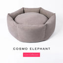 A beige / taupe-gray premium donut style dog bed, suitable for all breeds of dogs, with cosy high-wall dog bed sides and a deepfilled luxury mattress inside, on a white background with the text 'COSMO ELEPHANT' and 'Core Collection' below.