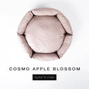 A top-down view of a pale apple-blossom pink luxury donut dog bed with high-wall padded sides and a round mattress inside, on a white background with the text 'COSMO APPLE BLOSSOM' and a black 'Styled To Order' label below.