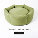 A luxury donut dog bed in soft pistachio green Cosmo fabric, suitable for all breeds of dogs, with cosy high-wall sides and a deep-filled luxury mattress inside, on a white background with the text 'COSMO PISTACHIO' and 'Styled To Order' below.