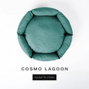 A top-down view of a deep teal green luxury donut dog bed with high-wall padded sides and a round mattress inside, on a white background with the text 'COSMO LAGOON' and a black 'Styled To Order' label below.