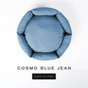 A top-down view of a mid denim blue luxury donut dog bed with high-wall padded sides and a round mattress inside, on a white background with the text 'COSMO BLUE JEAN' and a black 'Styled To Order' label below.