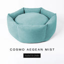 A luxury donut dog bed in pale aqua seafoam Cosmo fabric, suitable for all breeds of dogs, with cosy high-wall sides and a deep-filled luxury mattress inside, on a white background with the text 'COSMO AEGEAN MIST' and 'Styled To Order' below.