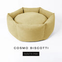A luxury donut dog bed in pale golden beige Cosmo fabric, suitable for all breeds of dogs, with cosy high-wall sides and a deep-filled luxury mattress inside, on a white background with the text 'COSMO BISCOTTI' and 'Styled To Order' below.