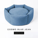 A luxury donut dog bed in mid denim blue Cosmo fabric, suitable for all breeds of dogs, with cosy high-wall sides and a deep-filled luxury mattress inside, on a white background with the text 'COSMO BLUE JEAN' and 'Styled To Order' below.