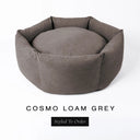 A luxury donut dog bed in warm taupe grey Cosmo fabric, suitable for all breeds of dogs, with cosy high-wall sides and a deep-filled luxury mattress inside, on a white background with the text 'COSMO LOAM GREY' and 'Styled To Order' below.