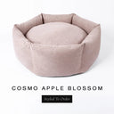 A luxury donut dog bed in pale apple-blossom pink Cosmo fabric, suitable for all breeds of dogs, with cosy high-wall sides and a deep-filled luxury mattress inside, on a white background with the text 'COSMO APPLE BLOSSOM' and 'Styled To Order' below.