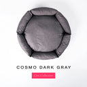A top-down view of a dark grey luxury donut dog bed with high-wall padded sides and a round mattress inside, on a white background with the text 'COSMO DARK GRAY' and a pink 'Core Collection' label below.
