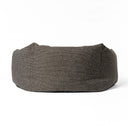 Side view of a  high-sided, calming donut dog bed made with a dark brown/black woven upholstery fabric on a white backdrop.