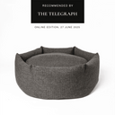 A luxury donut style dog bed, a round dog bed with high sides, in a dark brown woven fabric on a white backdrop and a 'Recommended by The Telegraph' press feature badge above.