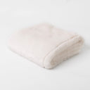 A folded pal cream faux fur dog blanket in Polar Bear taken on a white backdrop.
