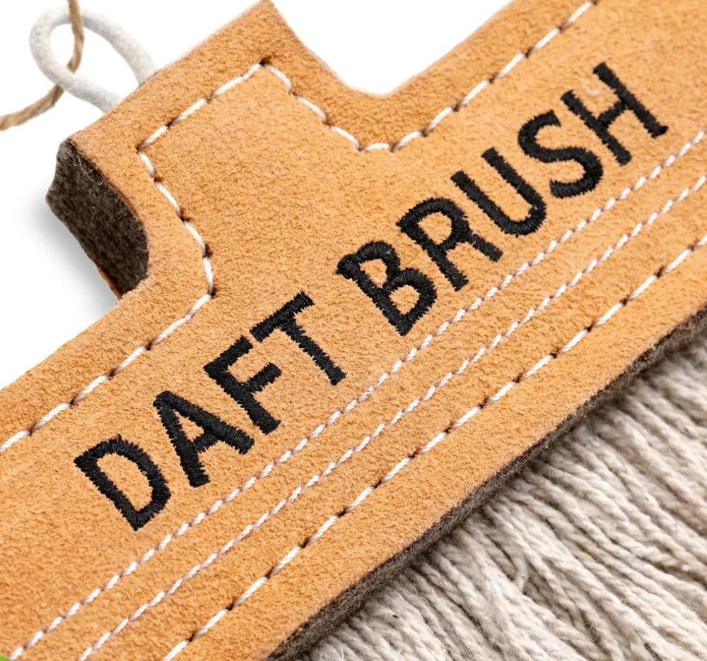 Close-up of a leather tag with 'DAFT BRUSH' text on a textured surface.