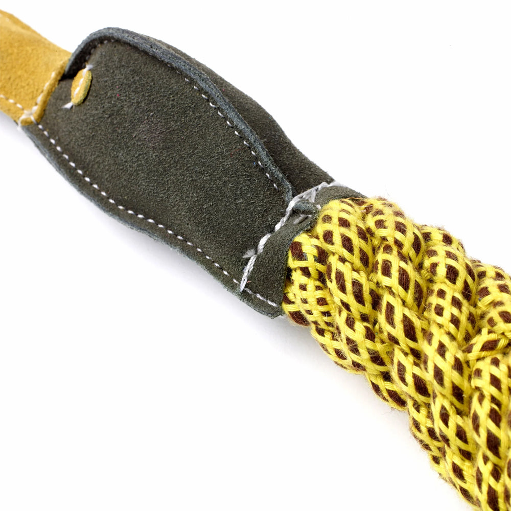 Close up of a dog Toy made from yellow jute rope with a duck-shaped head of green suede on a white background.