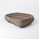 A luxury wicker dog bed made woven with rattan canes to create a natural Rattan Dog Basket on a white backdrop.