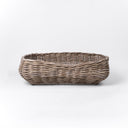 Front view of a luxury wicker dog bed made woven with rattan canes to create a natural Rattan Dog Basket on a white backdrop.