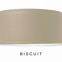A close-up of a bespoke plae beige leather dog collar with visible stitching, labelled 'BISCUIT' below on a white background.