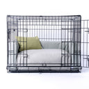 A wire dog dog crate with a luxury crate mattress and bed bumper set in pale beige/grey with a small pale yellow  mini-bolster pad cushion.