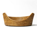 A contemporary round rattan dog basket in a natural rattan peel.