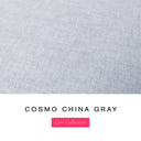 A fabric colour swatch of a premium upholstery quality dog bed fabric by dog bed designers Charley Chau, showing a light blue-grey upholstery cotton with the text 'COSMO CHINA GRAY' and a pink 'Core Collection' label below on a white background.