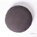 A round luxury dog bed mattress seen from above, in a dark brown/black woven upholstery fabric on a white backdrop. 
