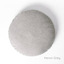 A round luxury dog bed mattress seen from above, in a grey woven upholstery fabric on a white backdrop. 