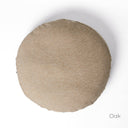 A round luxury dog bed mattress seen from above, in a beige woven upholstery fabric on a white backdrop. 