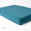 Close up shot of a luxury orthopaedic memory foam dog bed mattress with a durable jade green cover and a designer label for Charley Chau showing on a white backdrop. 
