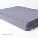 Detail shot of a grey luxury orthopaedic memory foam dog bed mattress with the designer label for Charley Chau showing on a white backdrop. 