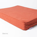 Detail shot of am orange orthopaedic memory foam dog bed mattress with the designer label for Charley Chau showing on a white backdrop. 