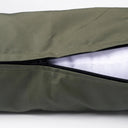 A close up of the zipper on an olive green  tough, water-resistant dog  revealing the white deep-filled mattress inside.