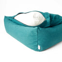A jade green luxury box bed style luxury dog bed with high sides and the dog bed mattress lifted up slightly with the zip unzipped revewaling the internal mattress pad on a white backdrop.