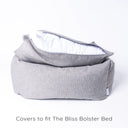Luxury box-style dog bed, Charley Chau's luxury Bliss Bolster dog Bed in a grey colour with the mattress lifted up slightly and the mattress cover unzipped to show the internal mattress insert on a white backdrop.