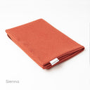 A folded Spare Dog Bed Cover in a hard-wearing upholstery fabric in orange on a white backdrop.
