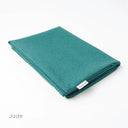 A folded Spare Dog Bed Cover in a durable upholstery fabric in jade green on a white backdrop. 