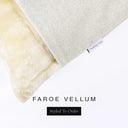 A close up detail of the corner of a Charley Chau Dog Snuggle Bed and dog Burrow Bag Dog Bed Cover with pale cream outer cover in woven wool texture upholstery-quality Faroe and plush cream faux-fur lining with a woven brand label showing the Charley Chau logo on a white backdrop.
